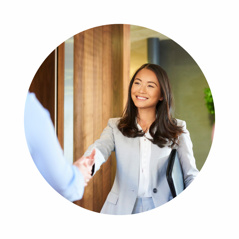 A woman in business attire shaking someone's hand